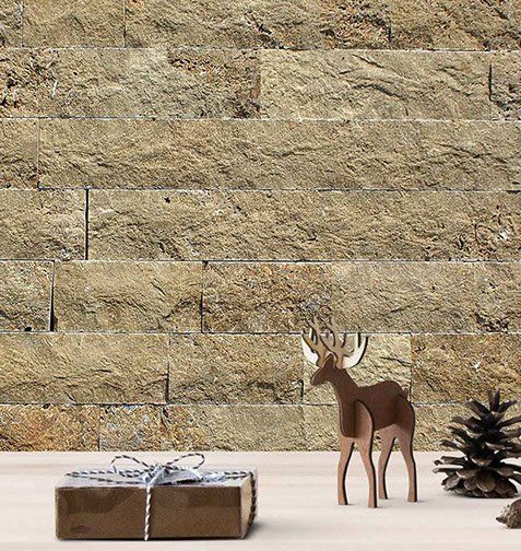 Stone wall background with gift box, wooden deer, and pine cone.