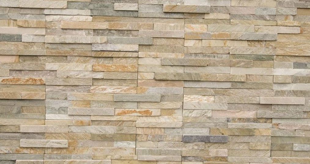 Stone wall with varying shades of beige, tan, and gray, in a stacked brick pattern.