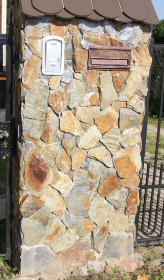Stone pillar with mailboxes, topped with a brown roof.