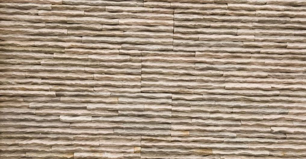Textured, beige stone wall with horizontal, uneven lines.