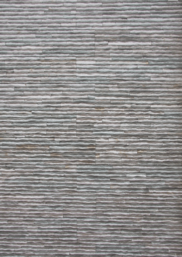 Gray textured wall with horizontal lines, possibly stone or tile.