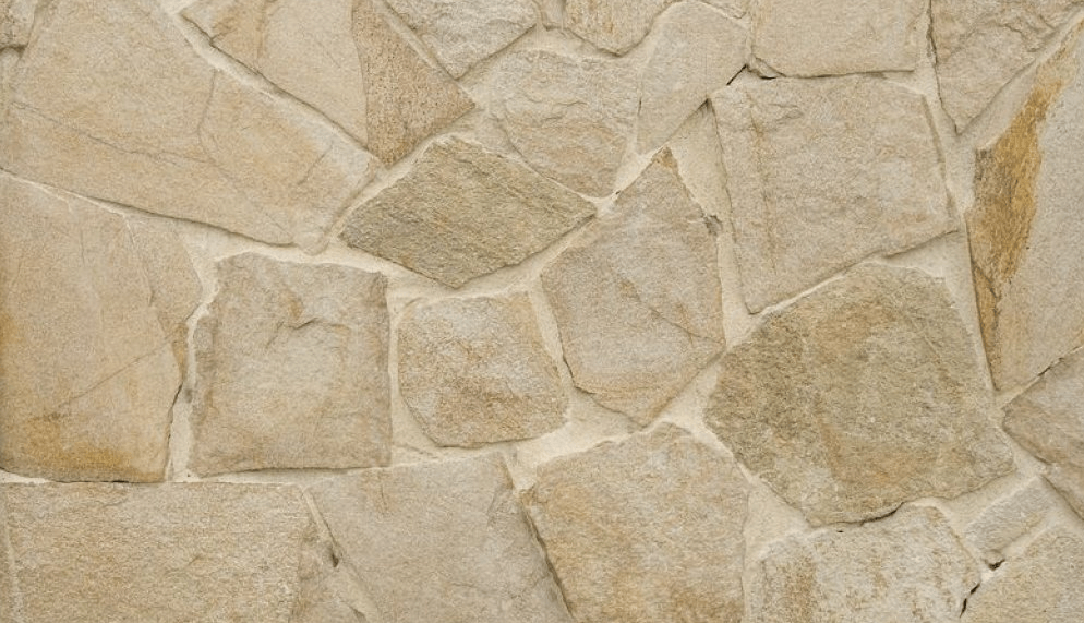 Rough-cut stone wall, beige and tan colors, irregular shapes with light-colored grout.