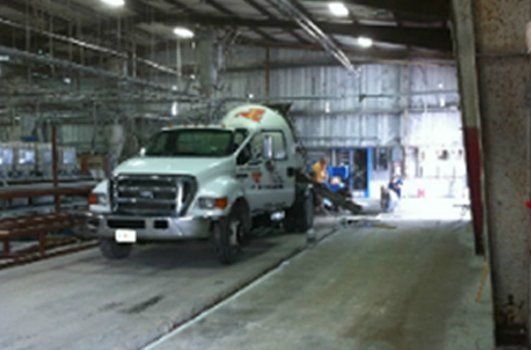A white truck is parked inside of a building