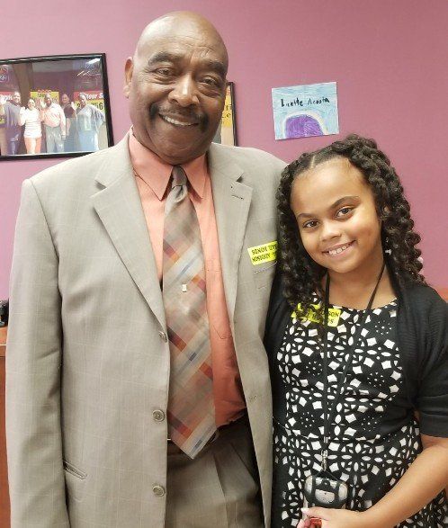A man in a suit and tie poses with a young girl