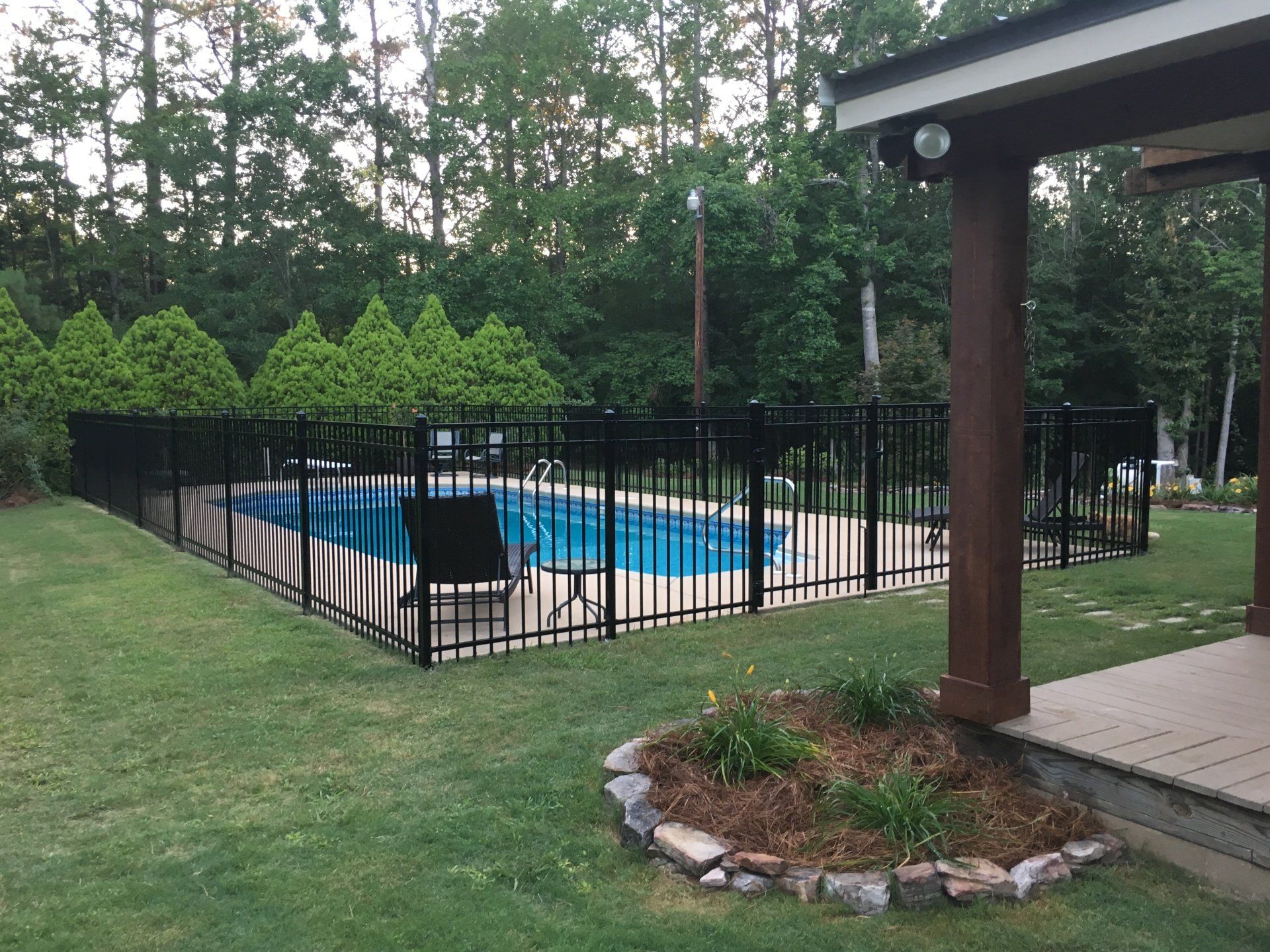 A large swimming pool with a black fence around it