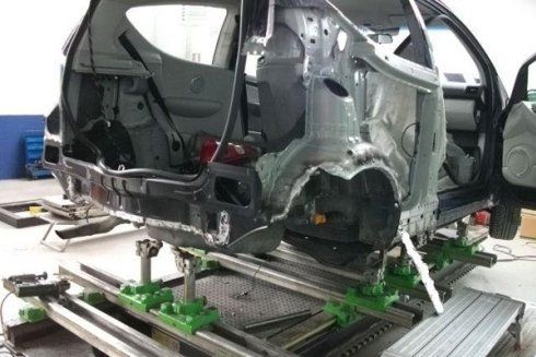 Carrozzeria danneggiata su un banco di riparazione in un'officina di carrozzeria.