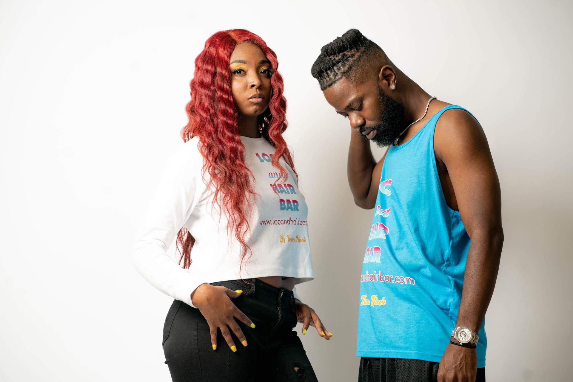 Two people posing against a white background, wearing colorful casual outfits.