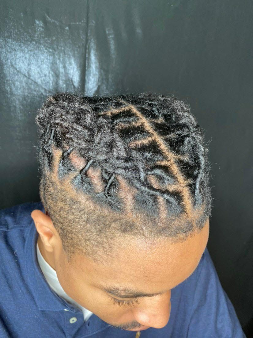 Top view of braided hair with a diagonal parting against a dark background