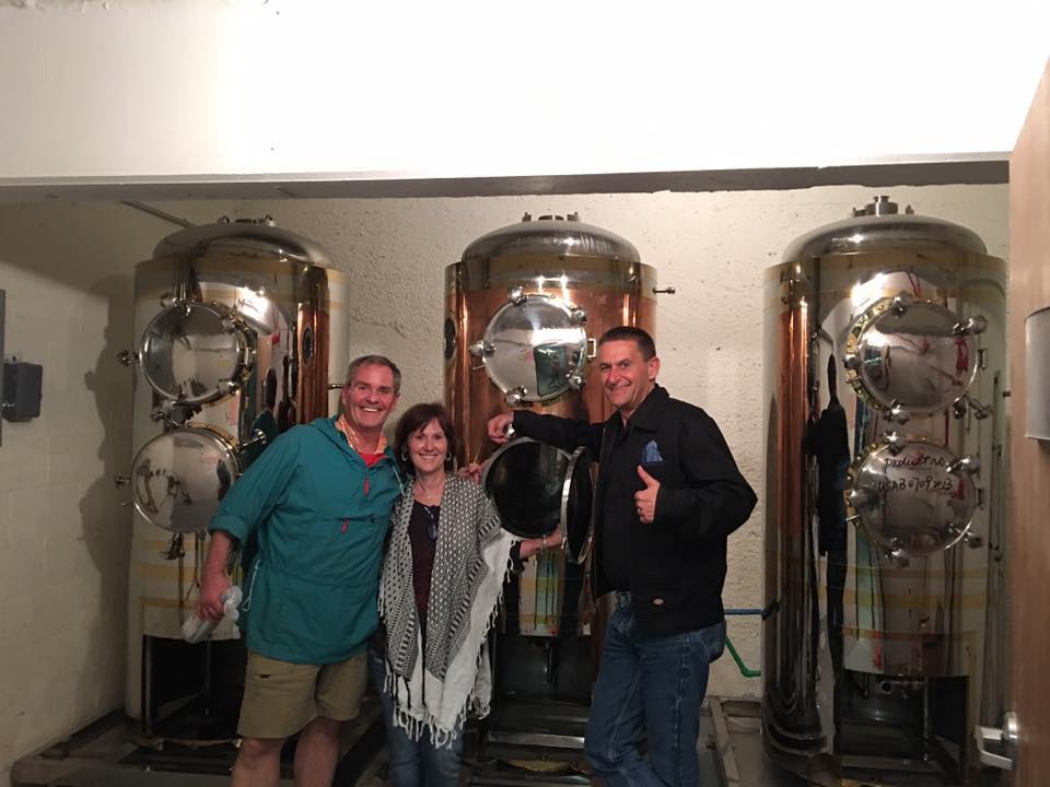 three people are posing for a picture in a room with a lot of tanks