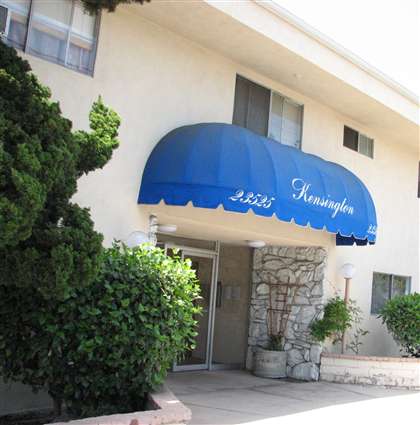 a building with a blue awning that says kensington