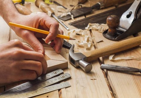 a Carpenter measuring wood with pencil and scale
