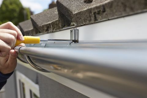 a technician installing new guttering systems
