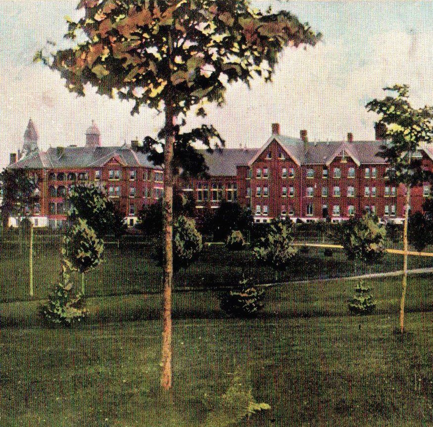A postcard showing a view of the institution during Alexander Beaton’s tenure as Superintendent. This image shows the two men’s cottages, A and B, as viewed from what is now Memorial Avenue. Between these two three storey brick buildings we can see the church-like structure of the institution’s recreation hall.) A postcard showing a view of the institution during Alexander Beaton’s tenure as Superintendent. This image shows the two men’s cottages, A and B, as viewed from what is now Memorial Avenue. Between these two three storey brick buildings we can see the church-like structure of the institution’s recreation hall.)