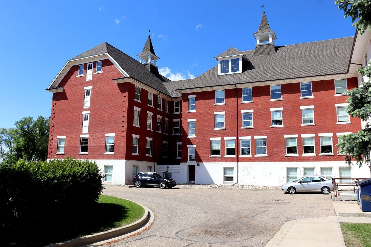 The main building of the Michener Centre in Red Deer, Alberta. It is a four storey red brick building with a peaked roof and two spires. The Michener Centre is the only large institution for people with intellectual/developmental disabilities in Canada that has no planned closure date. Image taken by Jason Woodhead, licensed under Creative Commons 2.0 (https://creativecommons.org/licenses/by/2.0/). The main building of the Michener Centre in Red Deer, Alberta. It is a four storey red brick building with a peaked roof and two spires. The Michener Centre is the only large institution for people with intellectual/developmental disabilities in Canada that has no planned closure date. Image taken by Jason Woodhead, licensed under Creative Commons 2.0 (https://creativecommons.org/licenses/by/2.0/).