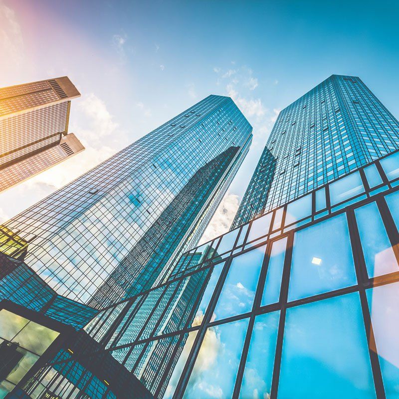 Bottom view of modern skyscrapers in business district in beautiful evening light at sunset with monochrome retro vintage Instagram style filter and lens flare effect