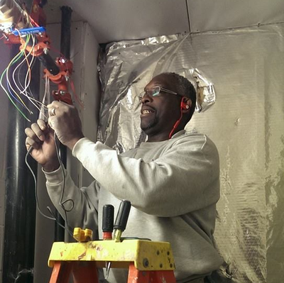 a man is standing on a ladder working on wires