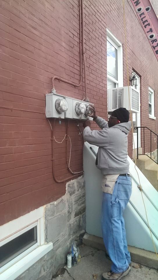 a man is working on an electrical box on the side of a building .