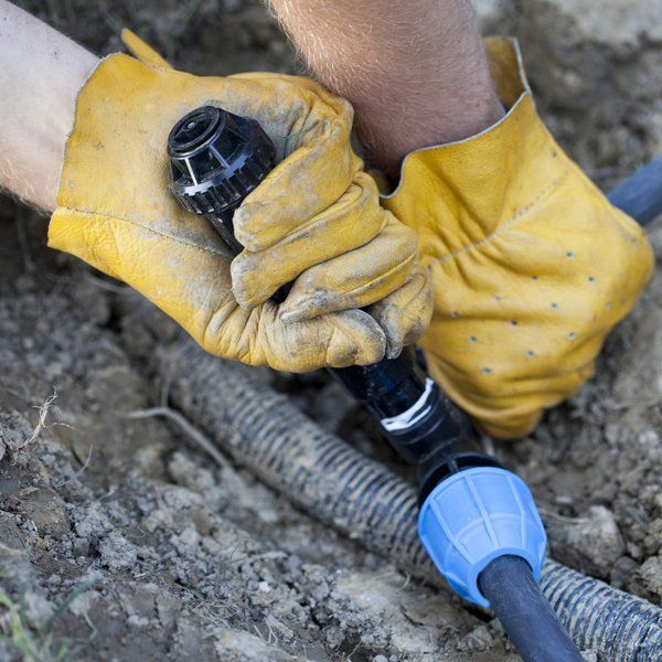 Worker installing a new sprinkler — Omaha, NE — Ground Control Irrigation Worker installing a new sprinkler — Omaha, NE — Ground Control Irrigation