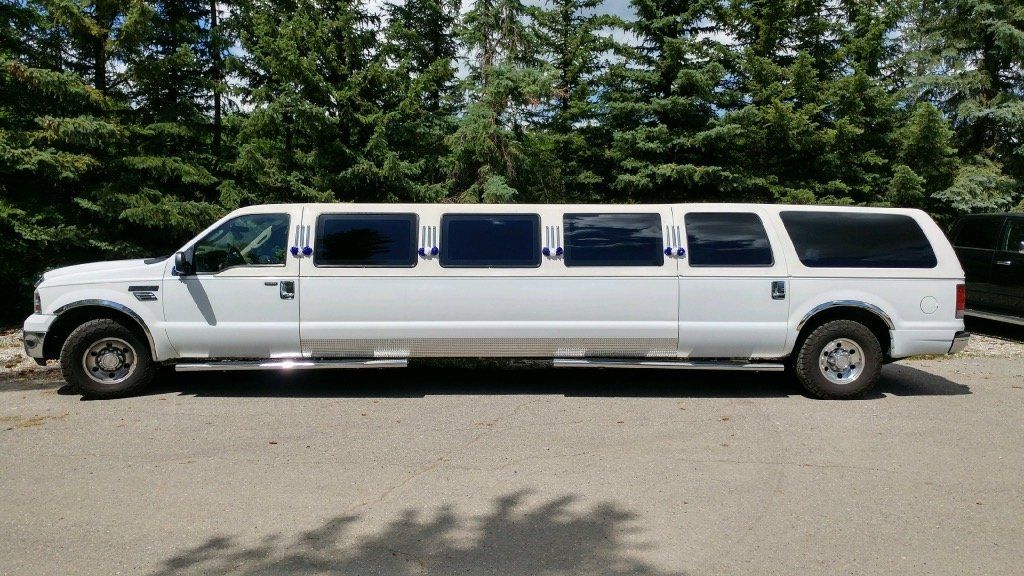white 14 passenger stretch Excursion limousine exterior side view
