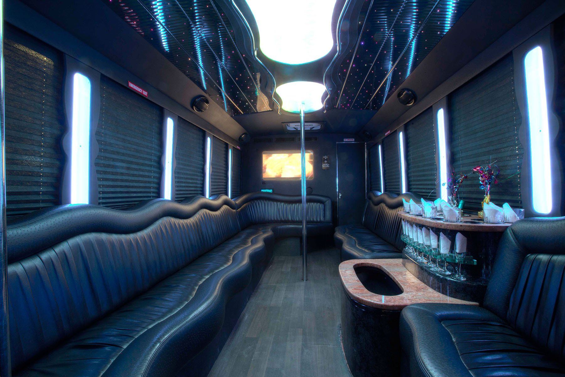 white E450 20 passenger party bus interior with pole,  bar area and black seating
