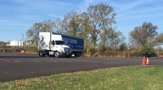 An MATC training day cab truck with a 53 foot trailer backing into a parking spot from a 90 degree angle