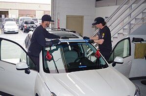 Mechanics Replacing Windshield — Auto Glass Repair in San Marcos, CA Mechanics Replacing Windshield — Auto Glass Repair in San Marcos, CA