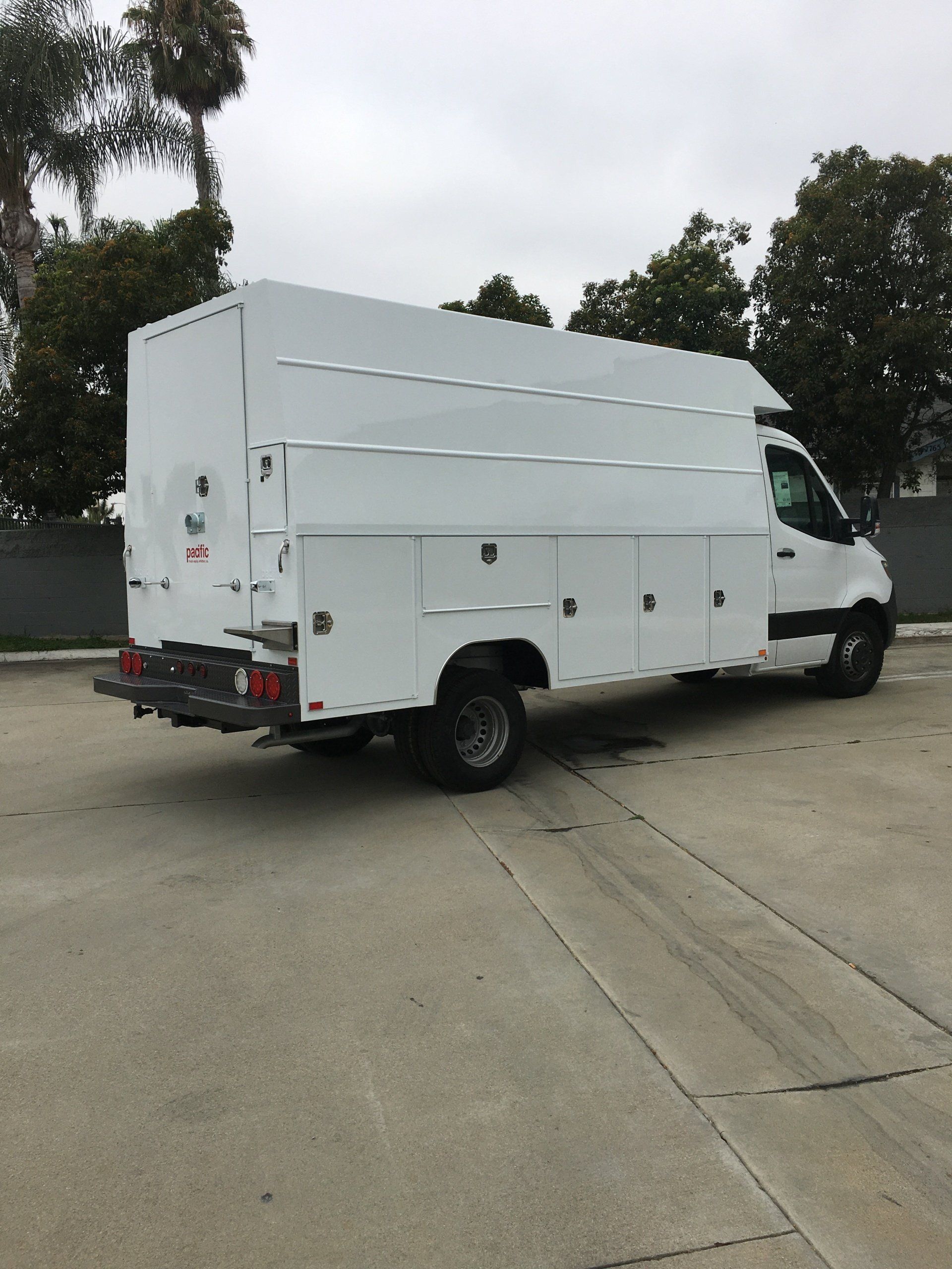 White utility van parked outdoors on pavement.
