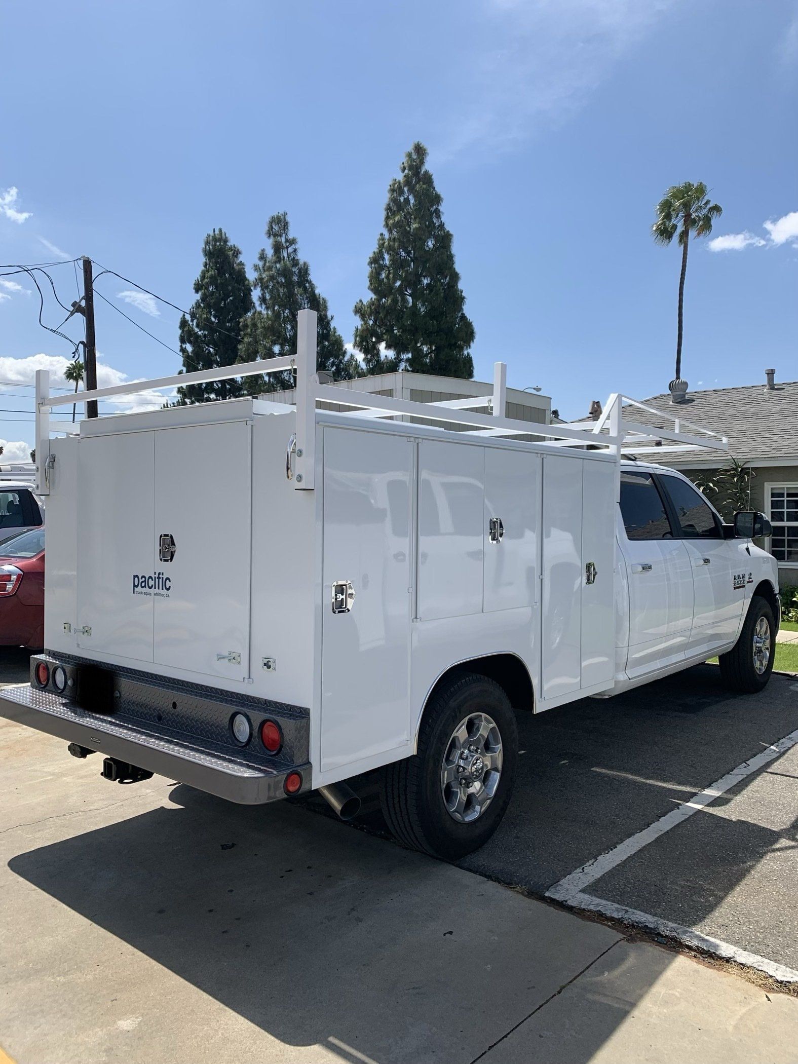White utility truck parked outside on a sunny day.