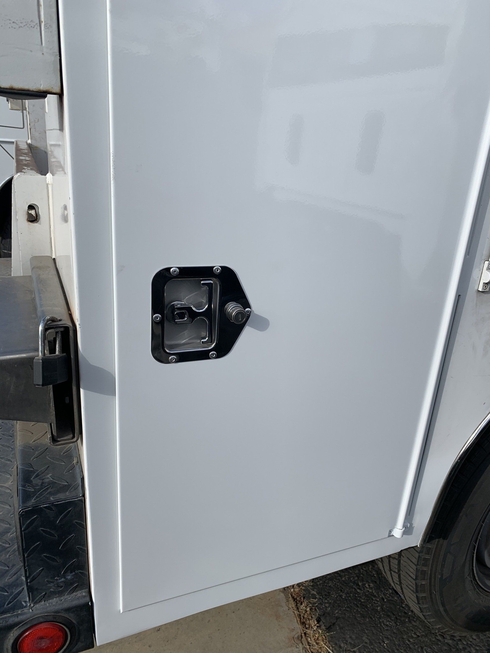 White truck side panel with a black latch.