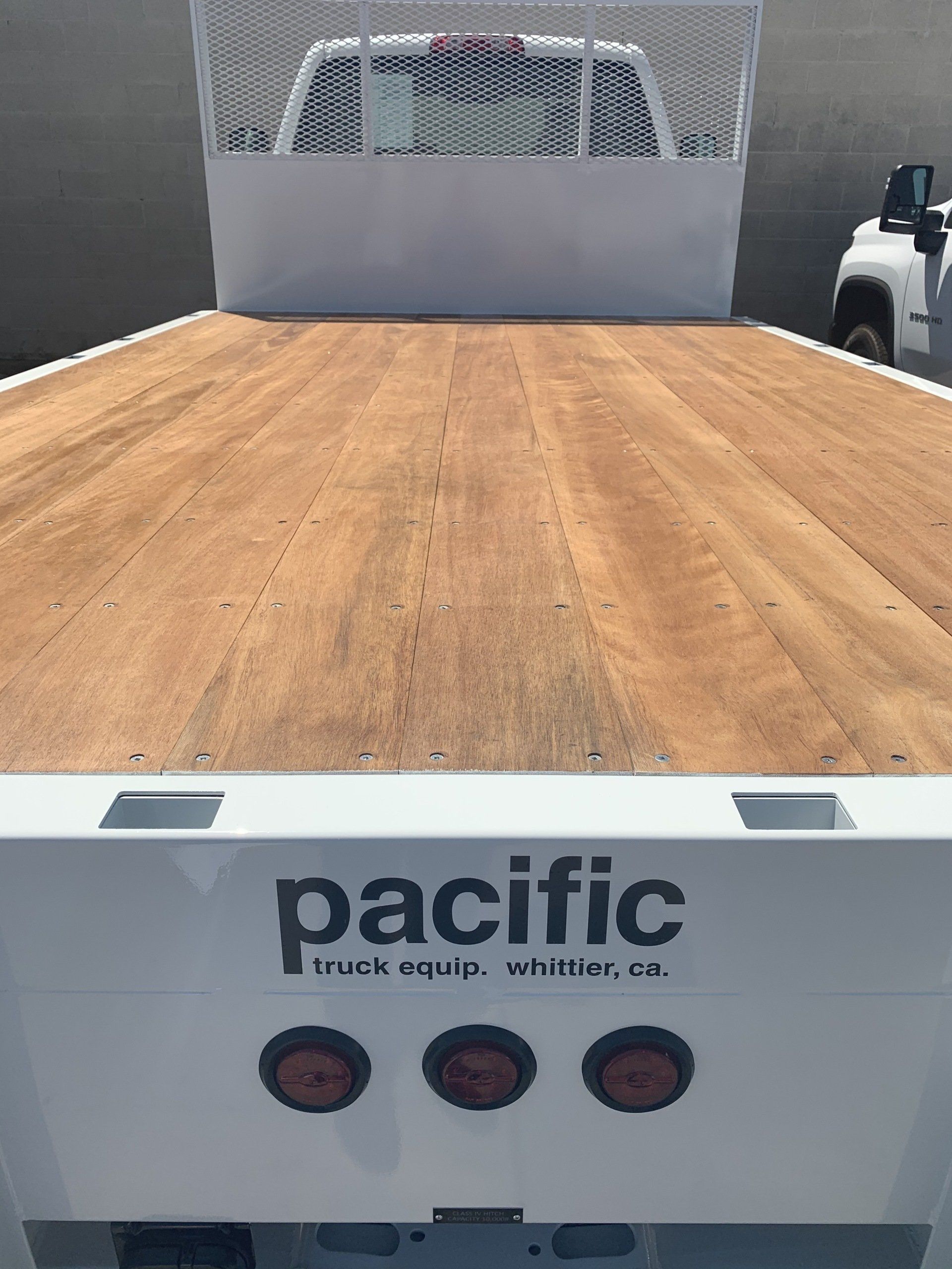Flatbed truck bed, white with wood.