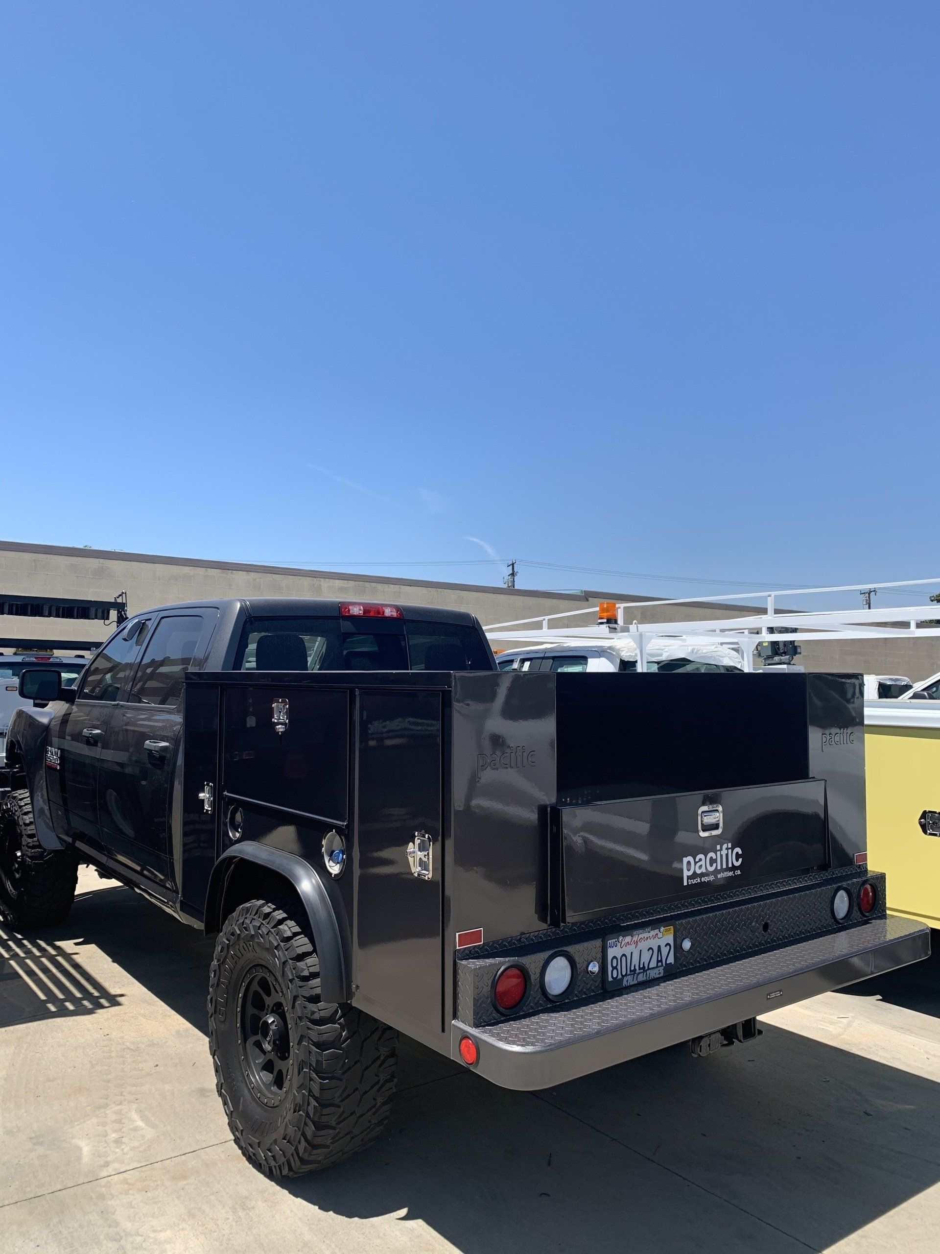 Black work truck with tool boxes on a sunny day.