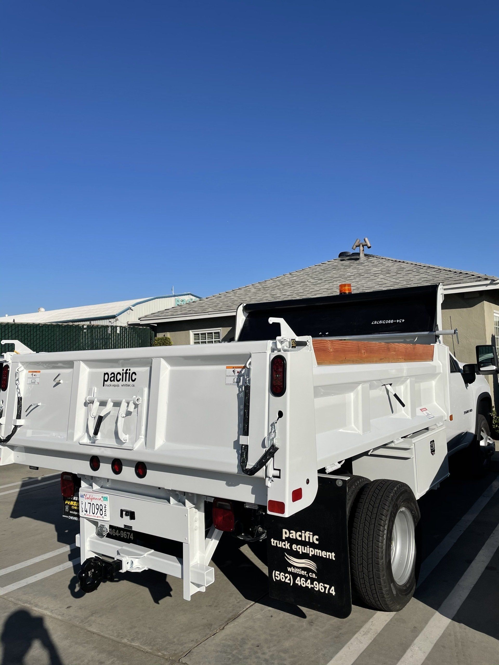 White dump truck parked outdoors on a sunny day.