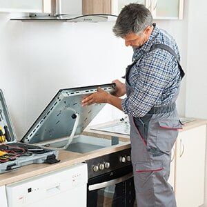 Man Repairing Stove - Stove Repair in Davison, MI Man Repairing Stove - Stove Repair in Davison, MI