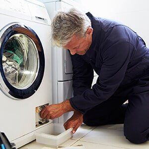 Man Repairing Dryer- Dryer Repair in Davison, MI Man Repairing Dryer- Dryer Repair in Davison, MI