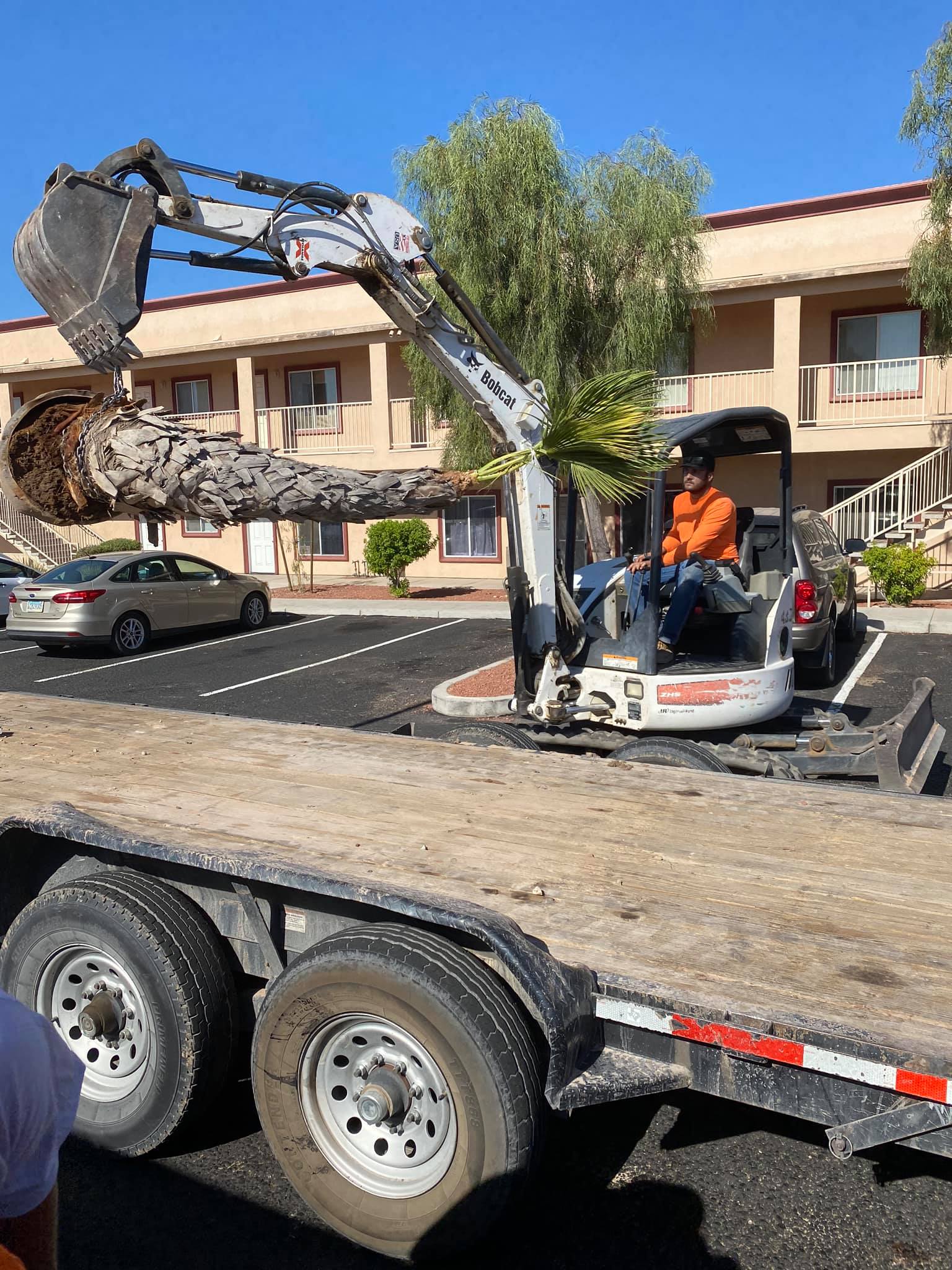 A man is driving a small excavator on a trailer.