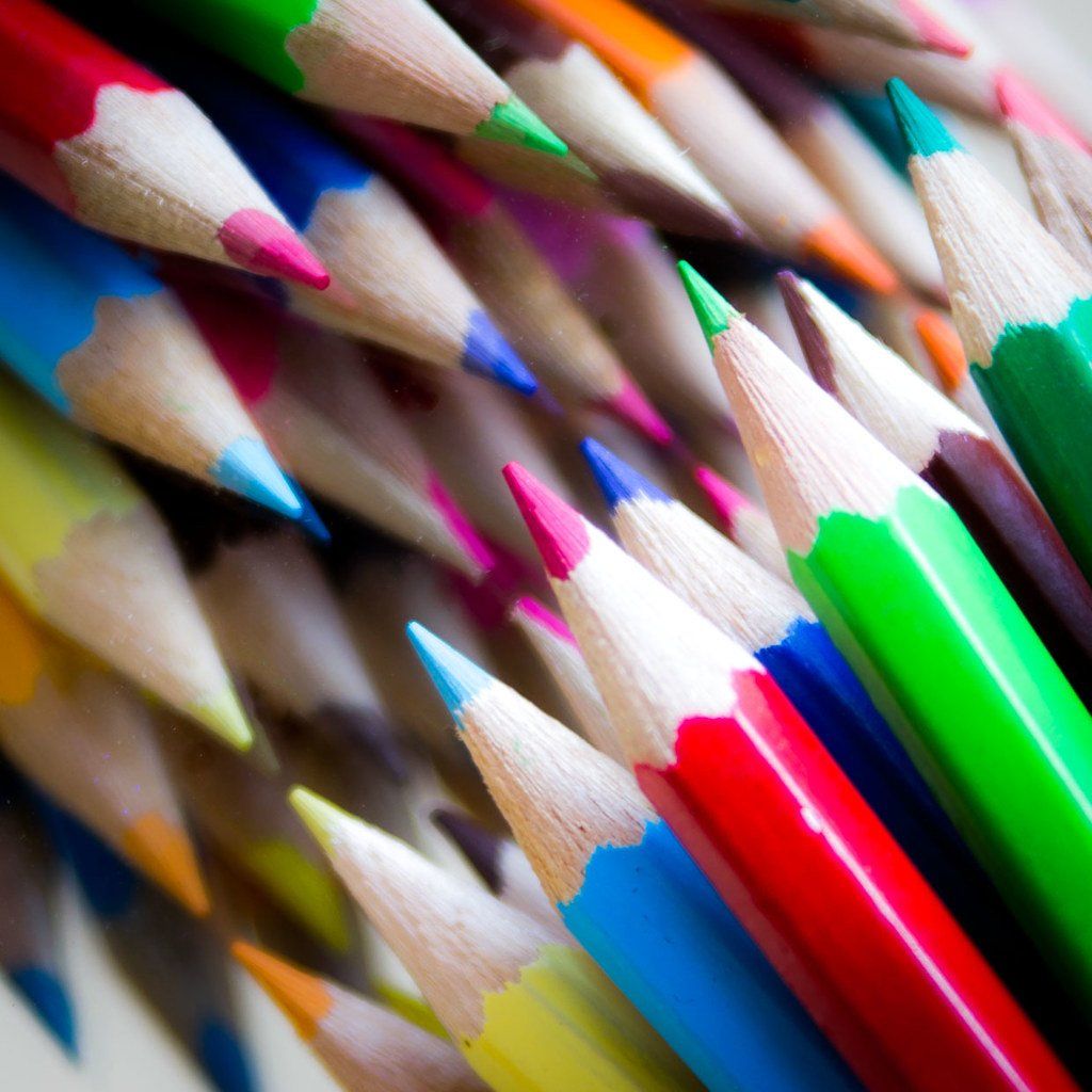 A bunch of colored pencils are stacked on top of each other