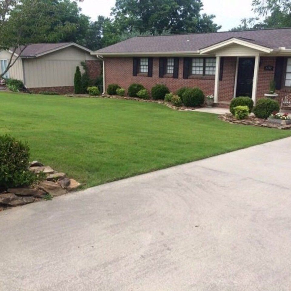 A brick house with a large lawn in front of it