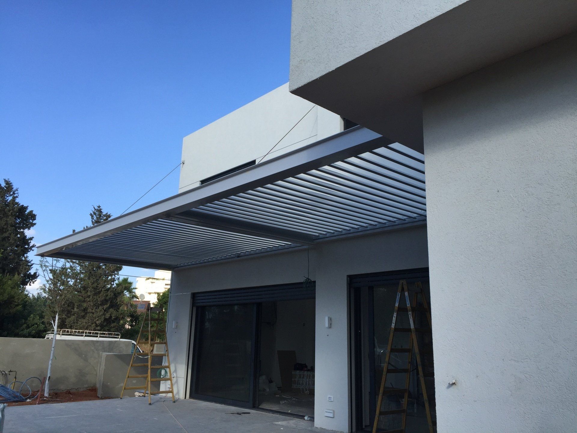House exterior with a large gray striped retractable awning over a patio entrance