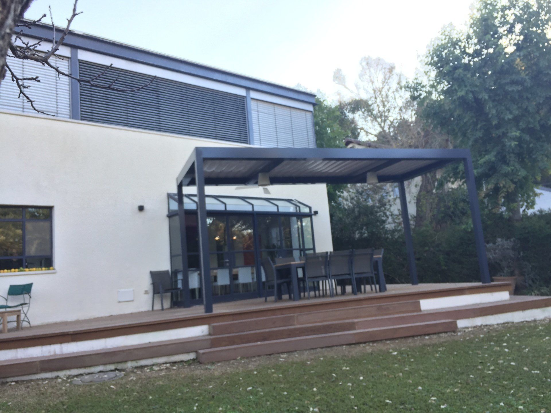 Modern house patio with a covered outdoor seating area and steps in front