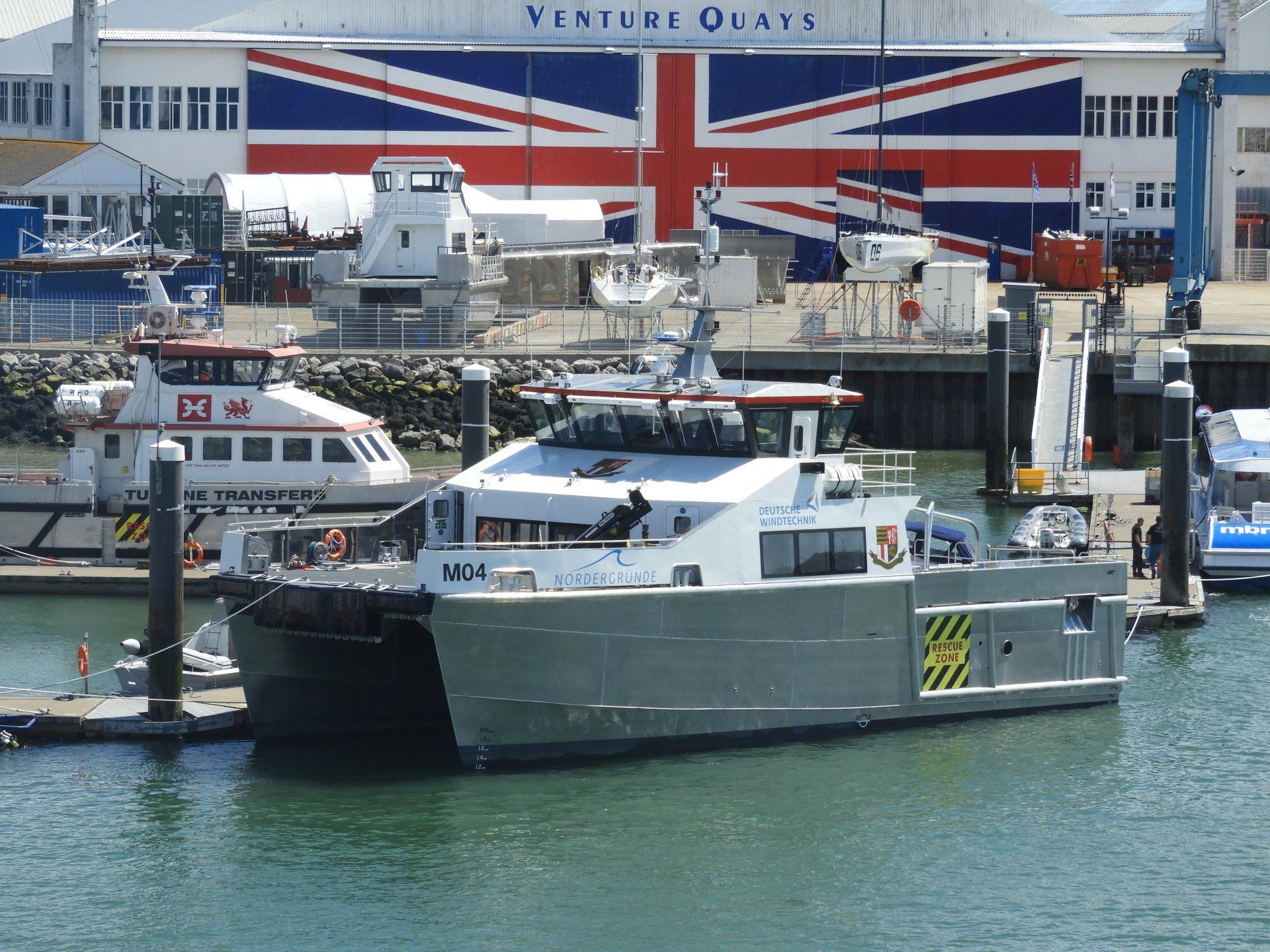 Ferry boat docked at a harbor with a Union Jack mural in the background