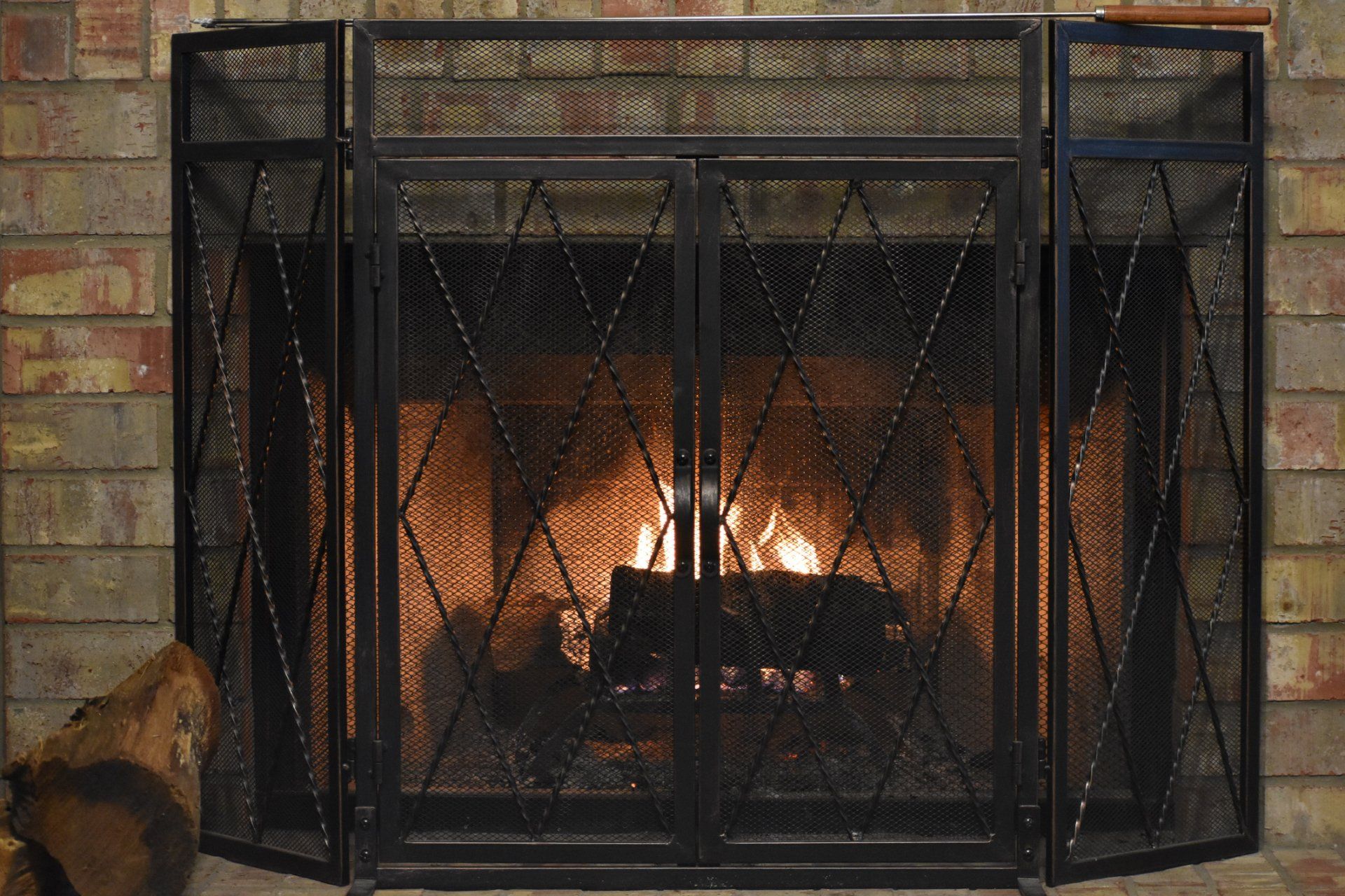 Chimney Cleaning — Fireplace With Log and Iron Screen and Blazing Fire in Rohnert Park, CA