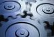 A close up of three gears on a blue background.