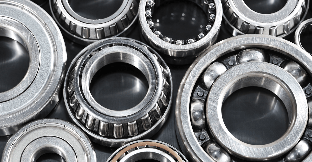 A bunch of bearings are sitting on top of each other on a black surface.
