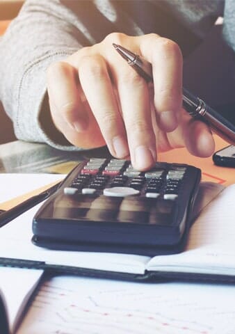 Man Using Calculator for Tax Preparation — S & S Tax And Financial Services, Inc. in Linden, NJ Man Using Calculator for Tax Preparation — S & S Tax And Financial Services, Inc. in Linden, NJ