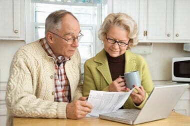 Couple with Laptop Checking their Retirement Plan — S & S Tax And Financial Services, Inc. in Linden, NJ Couple with Laptop Checking their Retirement Plan — S & S Tax And Financial Services, Inc. in Linden, NJ