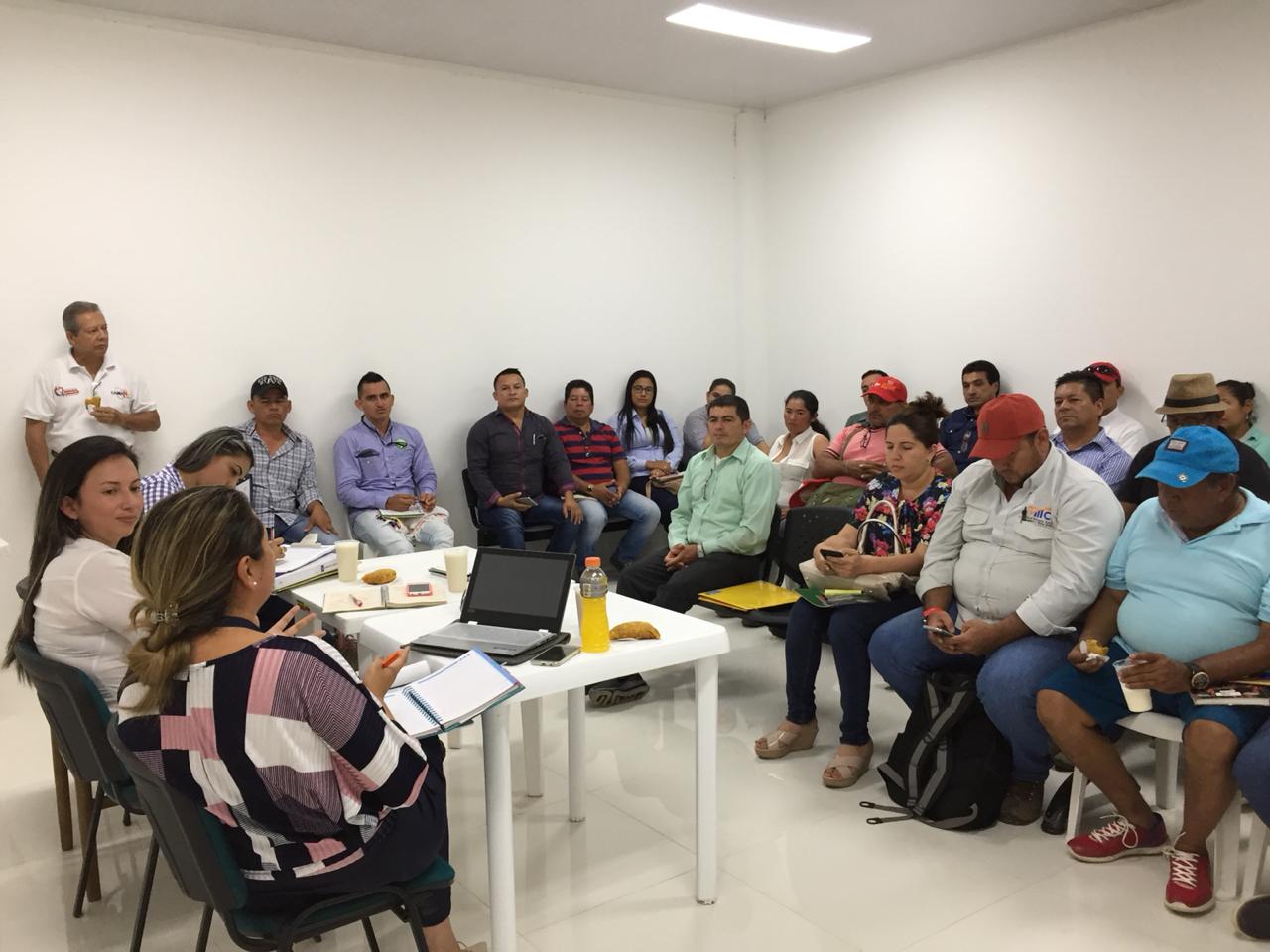 Un grupo de personas están sentadas alrededor de una mesa en una habitación.