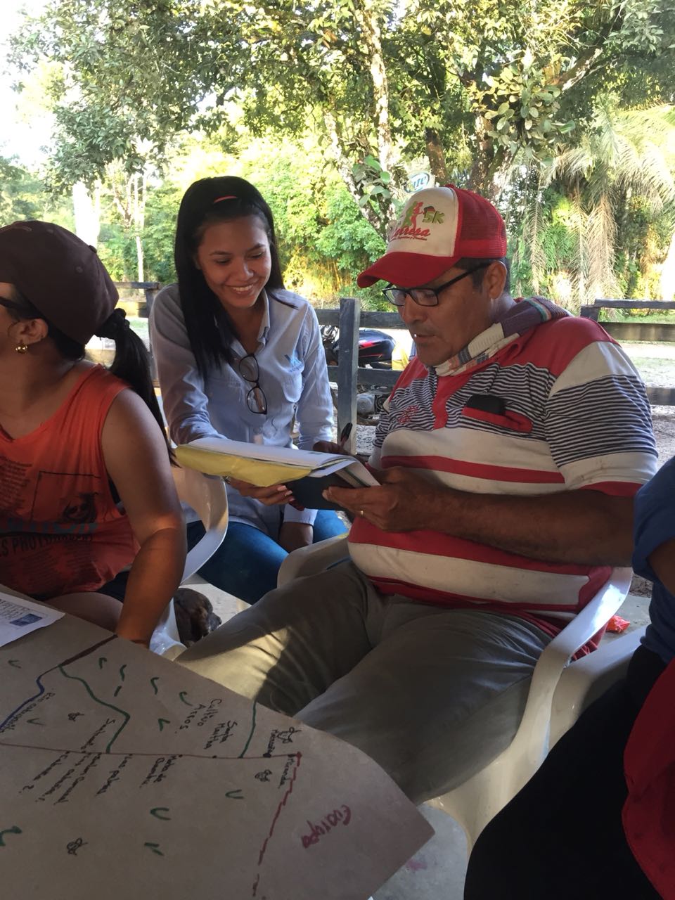Un grupo de personas están sentadas alrededor de una mesa con papeles encima.
