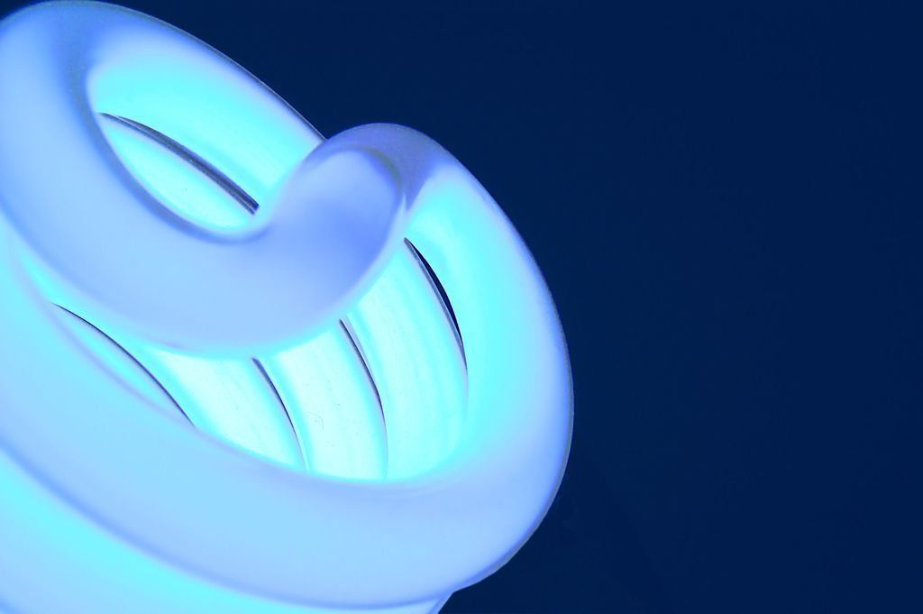 Una bombilla azul brilla en la oscuridad.