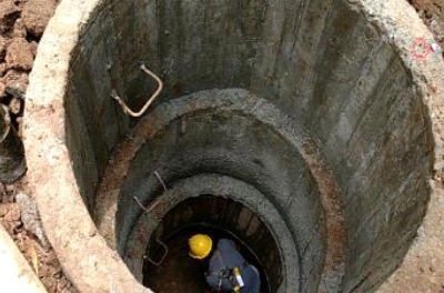 Un hombre está parado en medio de un pozo de concreto.