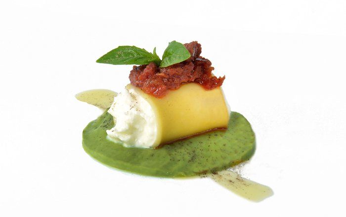 Un primo piano di un pezzo di cibo su una foglia verde